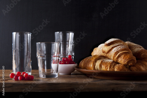 fresh hot Croissants and tableware for Breakfast. ripe red curra photo