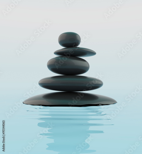Stack of black zen stones in water.