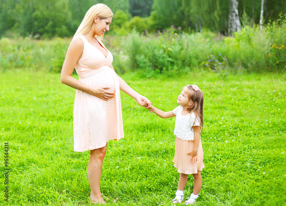 Pregnant woman, mother and little child daughter walking togethe Pregnant woman, mother and little child daughter walking togethe