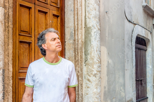 middle-aged man visiting medieval town alleys © Vivida Photo PC