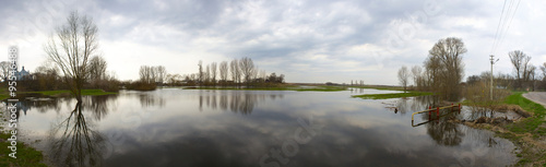 Spring flood with sky reflections and stormy weather. Panorama. © Garmon