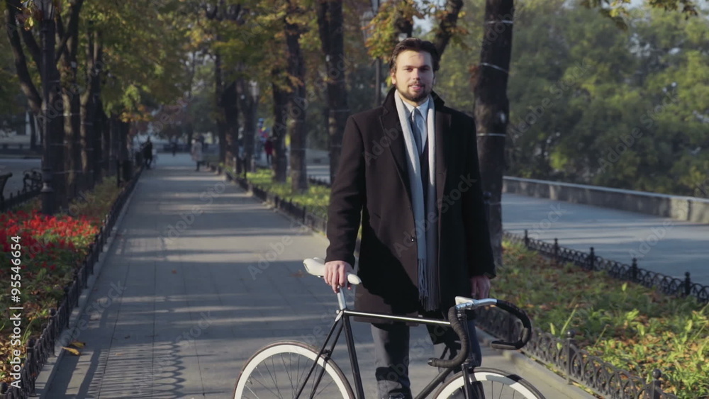 young businessman standing with bicycle young businessman standing with bicycle