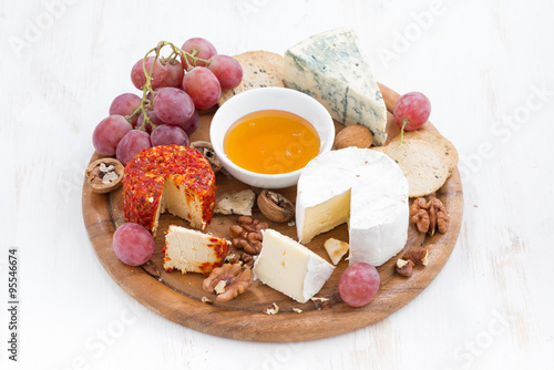 cheeses and snacks on a wooden board