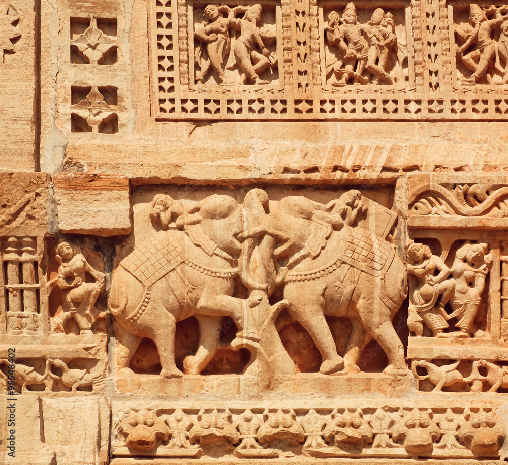 Indian elephants of massive stone bas-relief on the front of historical wall of temple, India