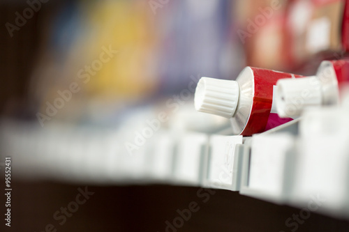 Hairdresser's hand taking tube with a paint for hair photo