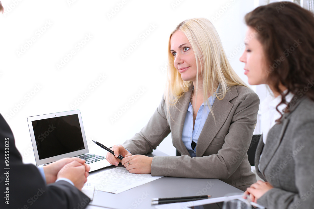 A group of business people at a meeting on the background of office. Focus on a beautiful blonde A group of business people at a meeting on the background of office. Focus on a beautiful blonde