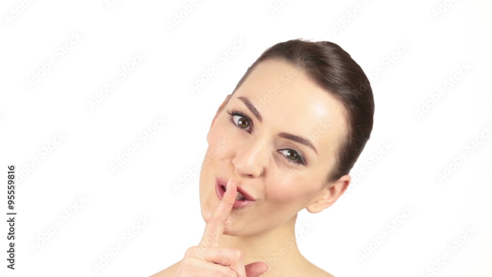 Beautiful young woman expressing silence with her finger on lips