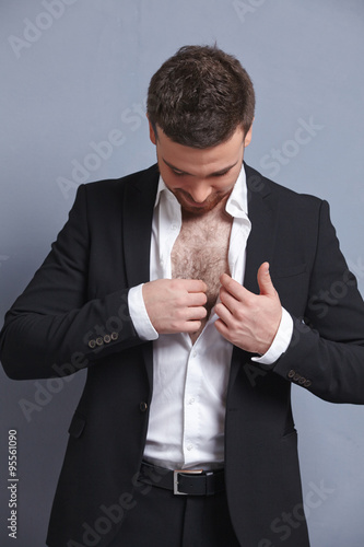 businessman puts his hand inside his jacket