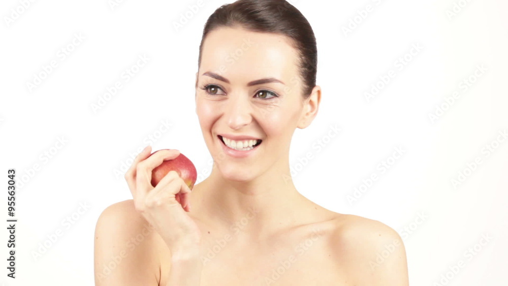 Attractive young woman smiling and catching a fresh red apple Attractive young woman smiling and catching a fresh red apple