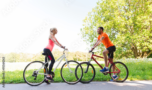 happy couple riding bicycle outdoors