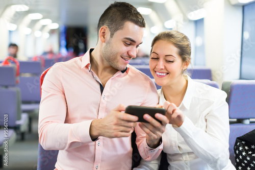 Young couple with smartphones in train
