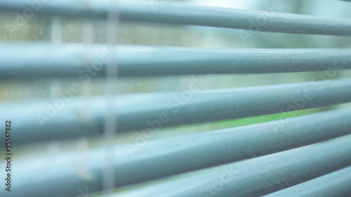 Large window blinds opening showing a cold wet day photo