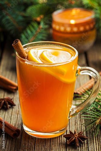 Traditional hot toddy winter drink with spices recipe. Healthy organic homemade holiday celebration beverage in glass. Vintage wooden background