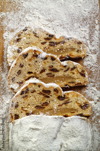 Drei Scheiben Weihnachtsstollen auf einem Holzbrett