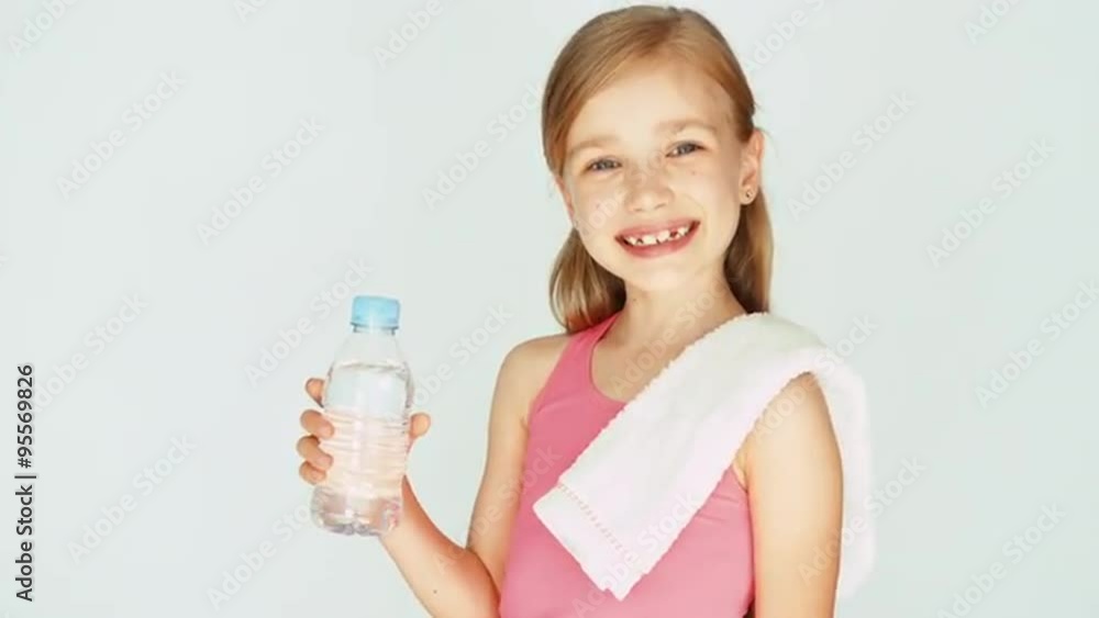 Portrait sportswoman girl child showing bottle of water at camera. Zooming Portrait sportswoman girl child showing bottle of water at camera. Zooming