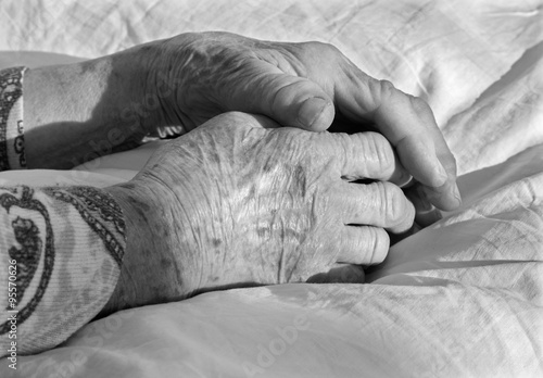 hands of old woman on the bed photo