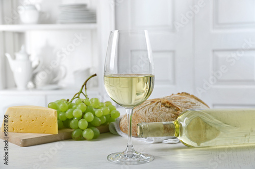 Still life of wine, grape, cheese and bread on light background