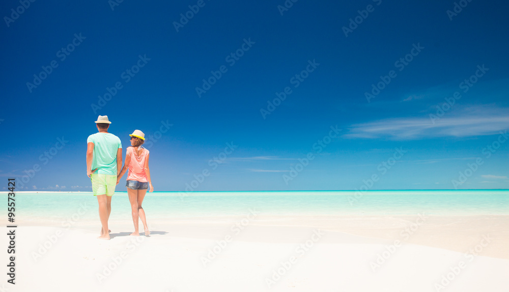 Couple in bright clothes having fun at tropical beach
