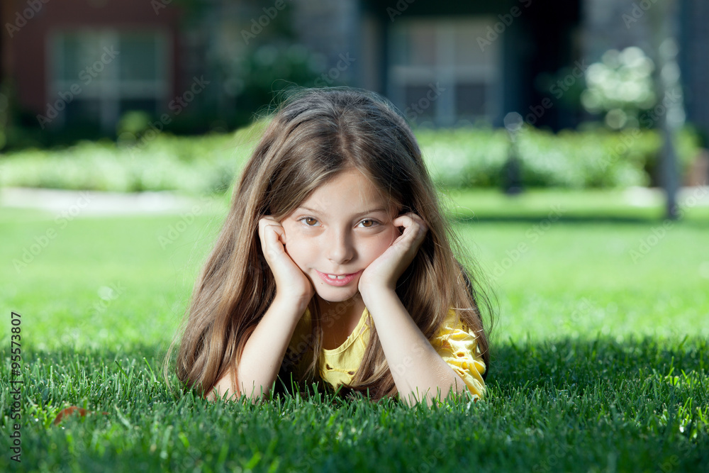portrait of little girl laying on the grass in summer environment portrait of little girl laying on the grass in summer environment