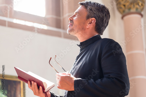 Catholic priest reading bible in church photo