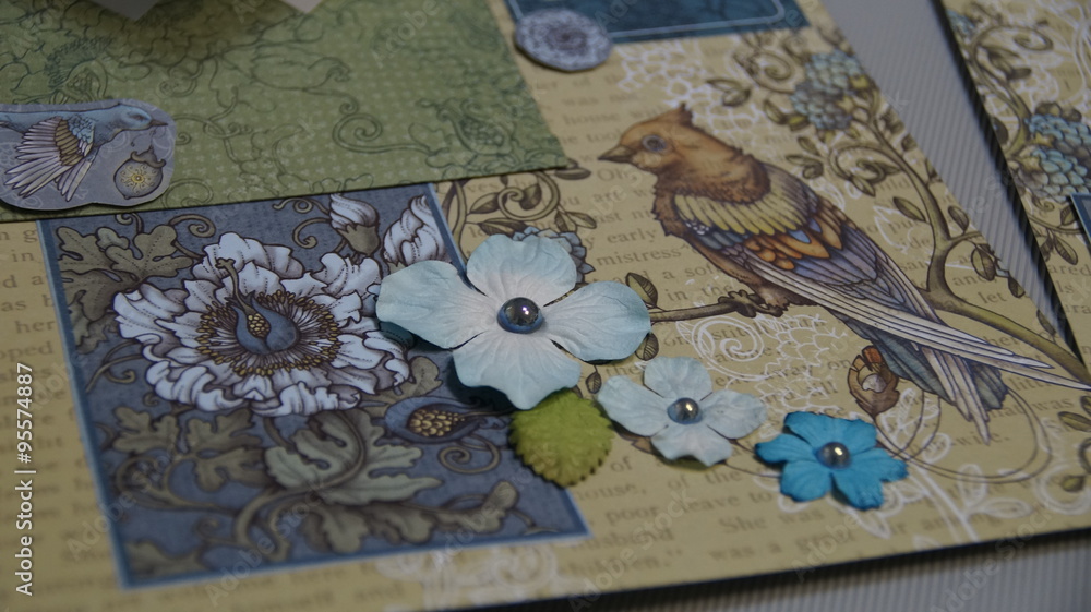 the process of handmade creating of the album from special scrapbooking paper, paper flowers and other decorative elements