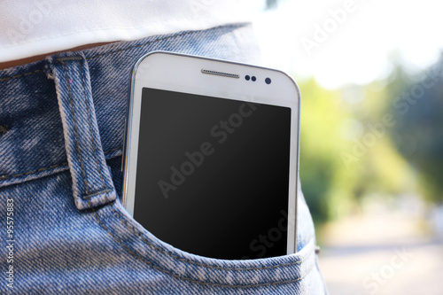 White smart mobile phone in jeans pocket photo