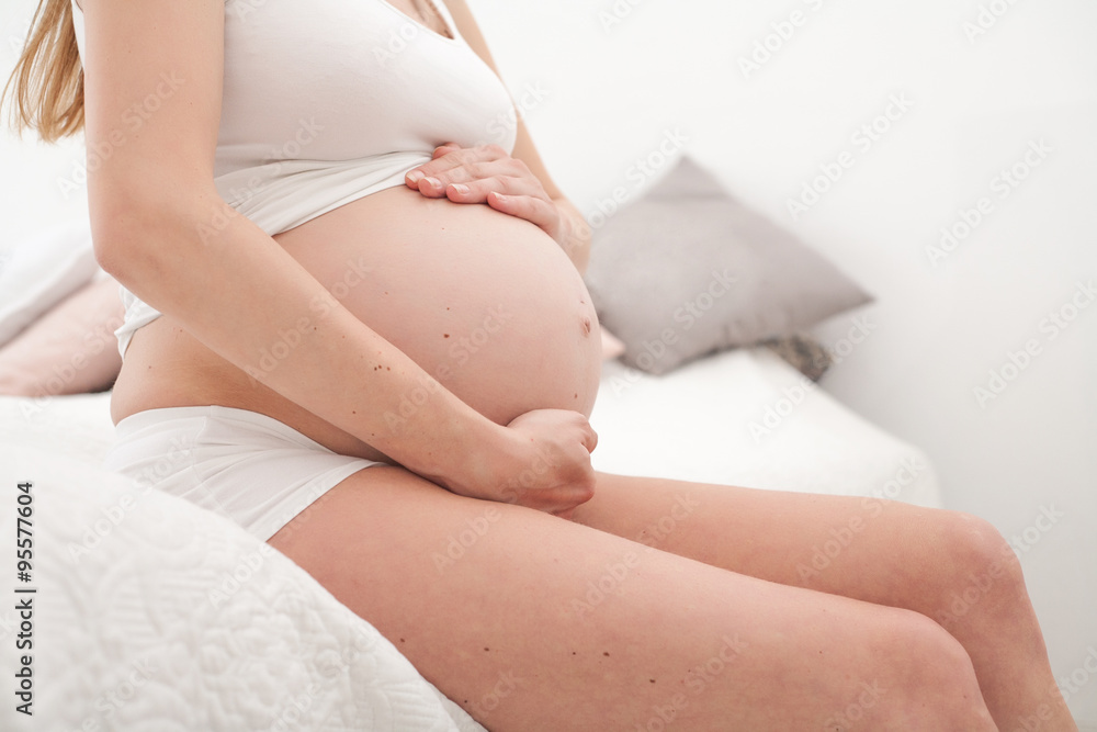 Profile of pregnant woman on bed