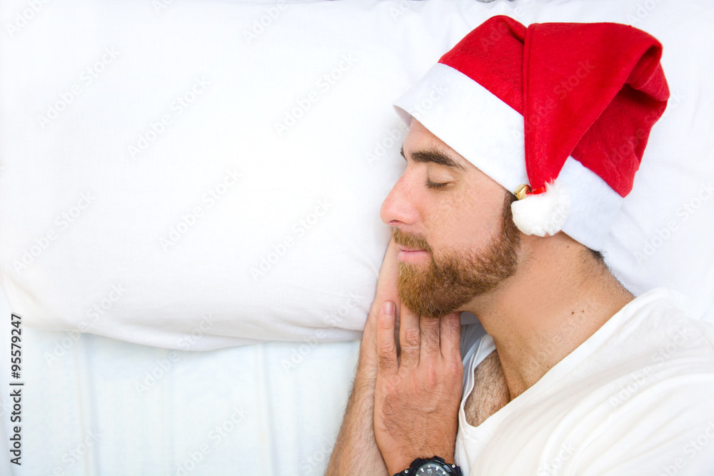 Man with santa hat sleeping in bed Man with santa hat sleeping in bed