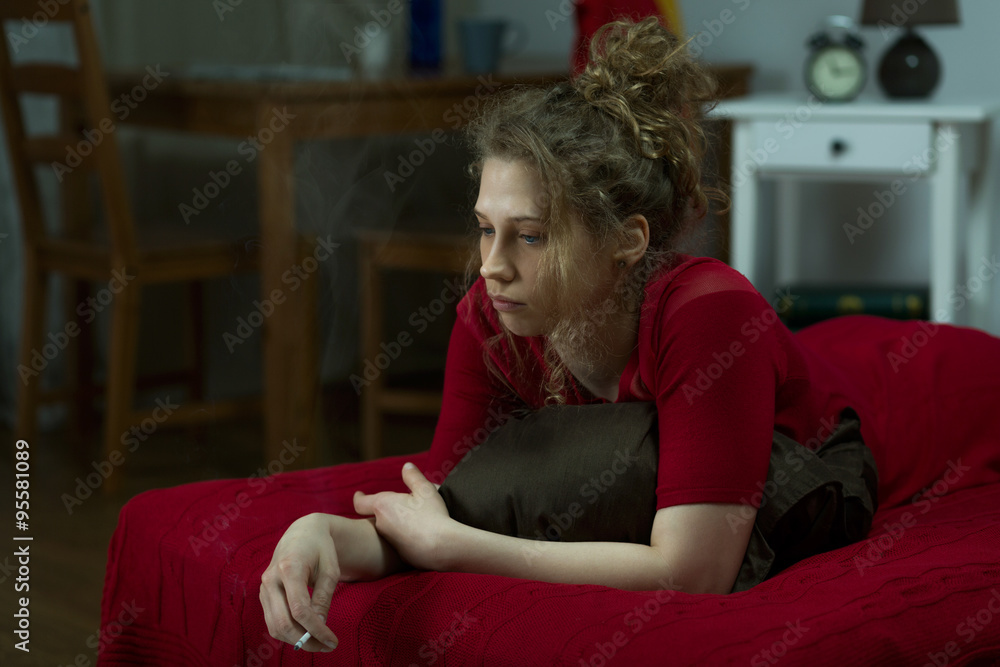 Obraz premium Depressed woman smoking cigarette