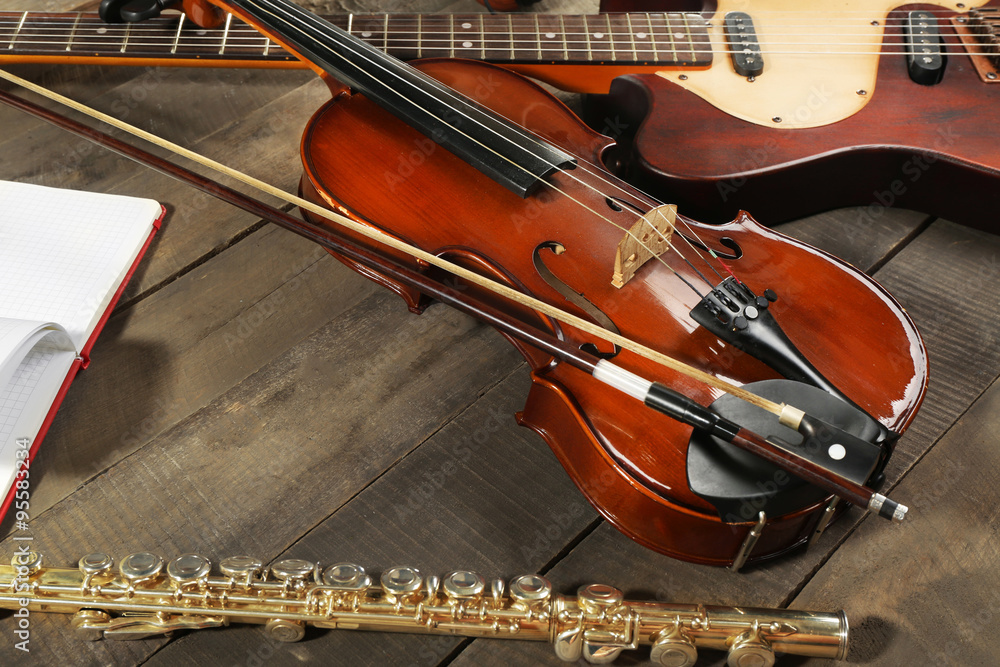 Fototapeta premium Electric guitar, violin, soprano saxophone and book on wooden background