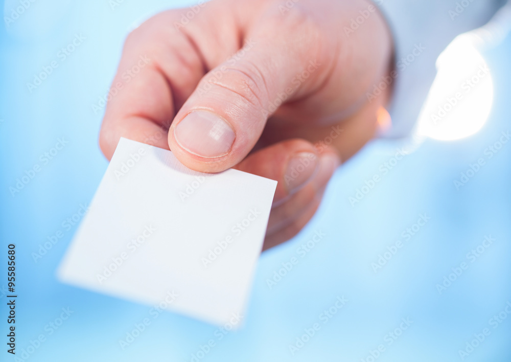 Man's hand reaching out a business card Man's hand reaching out a business card