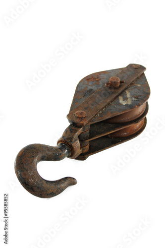 An old and rustic pulley hook on a clean, white background.