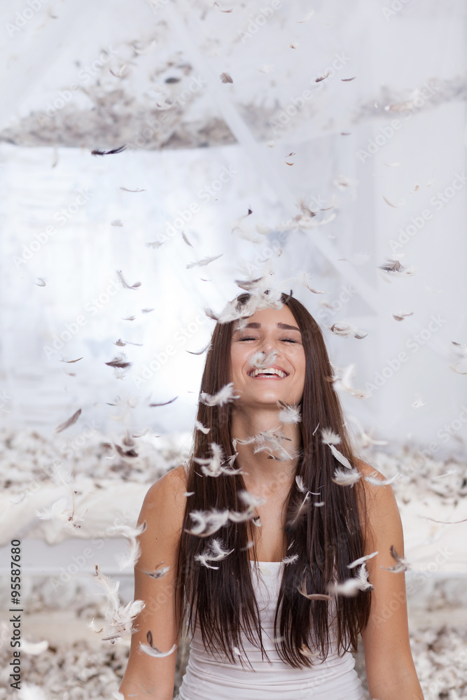 Naklejka premium soft feathers are falling to laughing girl