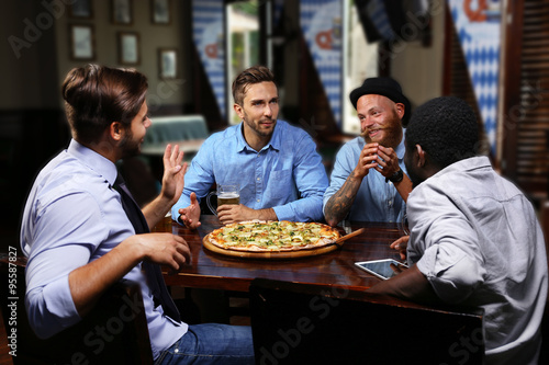 Young people eating pizza a...