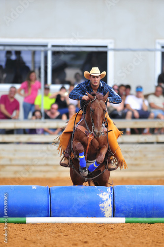 The rider jumping with horse over barrels