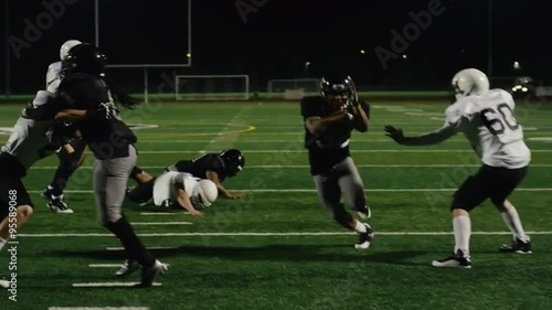 A football player runs for a touchdown with opponents trying to tackle him