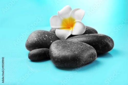 Spa stones and flower on blue background