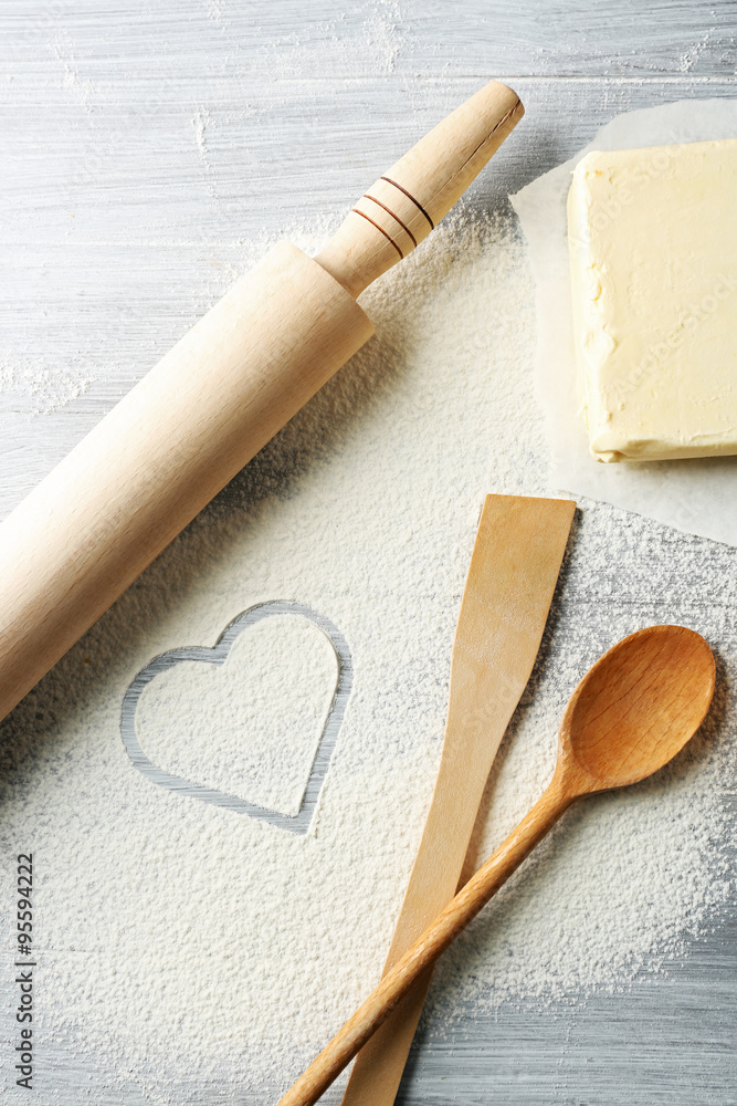 Heart of flour, croissant and wooden kitchen utensils on gray background Heart of flour, croissant and wooden kitchen utensils on gray background