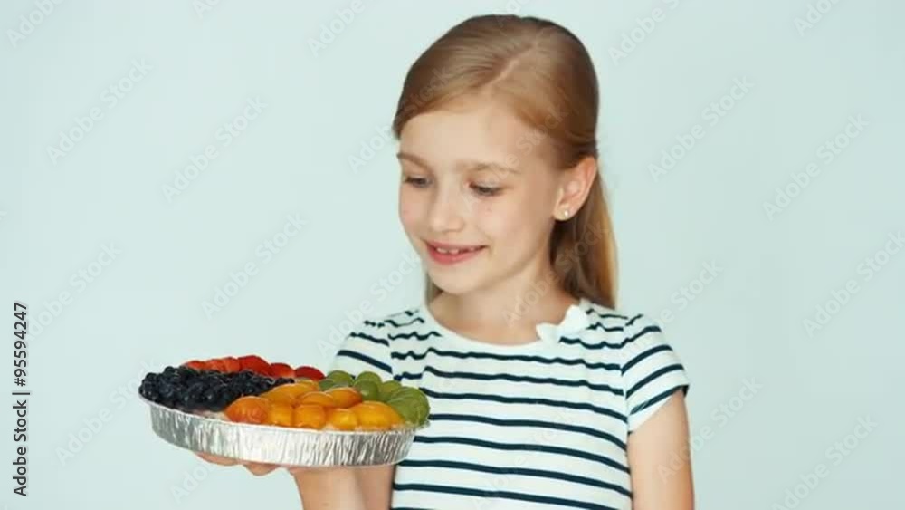 Closeup portrait girl holding cake with fruit on the white background. Thumb up. Ok Closeup portrait girl holding cake with fruit on the white background. Thumb up. Ok