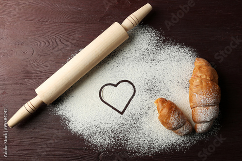 Fototapeta Naklejka Na Ścianę i Meble -  Heart of flour, croissants and rolling pin on table background