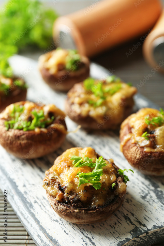 Stuffed mushrooms on wooden board, on table background Stuffed mushrooms on wooden board, on table background