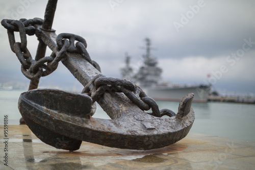 Anchor on the embankment and the cruiser in the port of Novoross