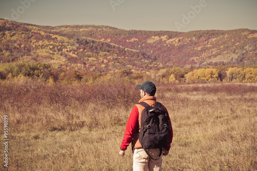 Male tourist with backpack sotret on the horizon in autumn © volkovslava