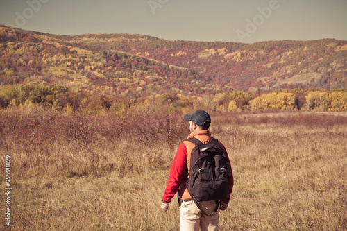 Male tourist with backpack sotret on the horizon in autumn