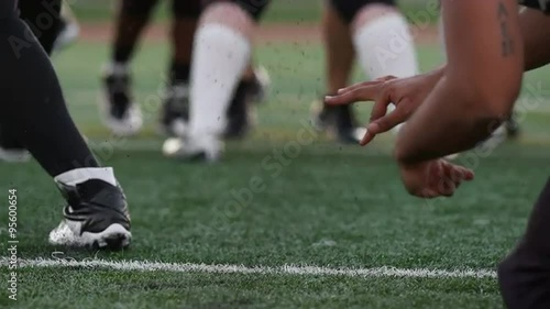 Close up of a football player kicking the ball toward the goal posts