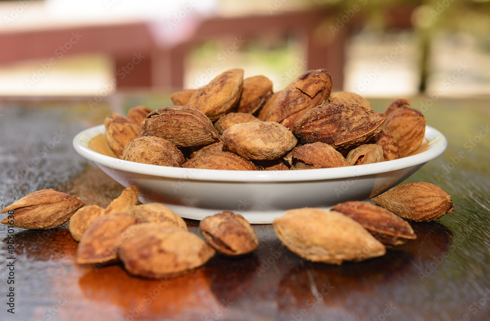 Seeds, almonds, toasted on wood table Keep the focus on plate almonds seeds Blur the foreground and background . Seeds, almonds, toasted on wood table Keep the focus on plate almonds seeds Blur the foreground and background .