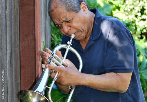 African american jazz musician with his flugelhorn outdoors.