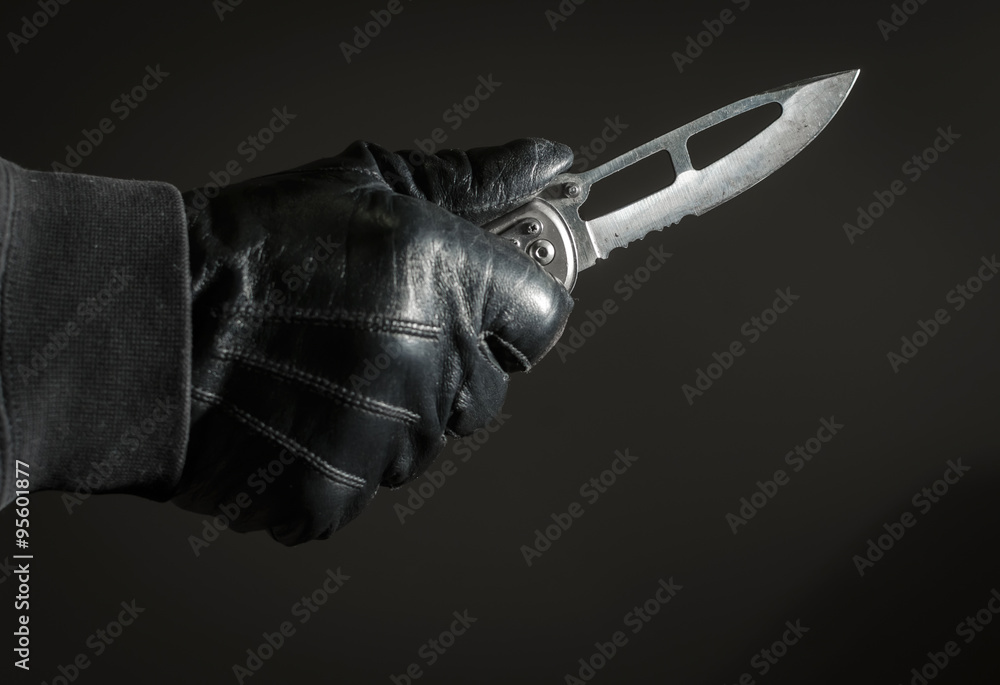 Mugger Holding Knife with Black Leather Gloves Stock Photo