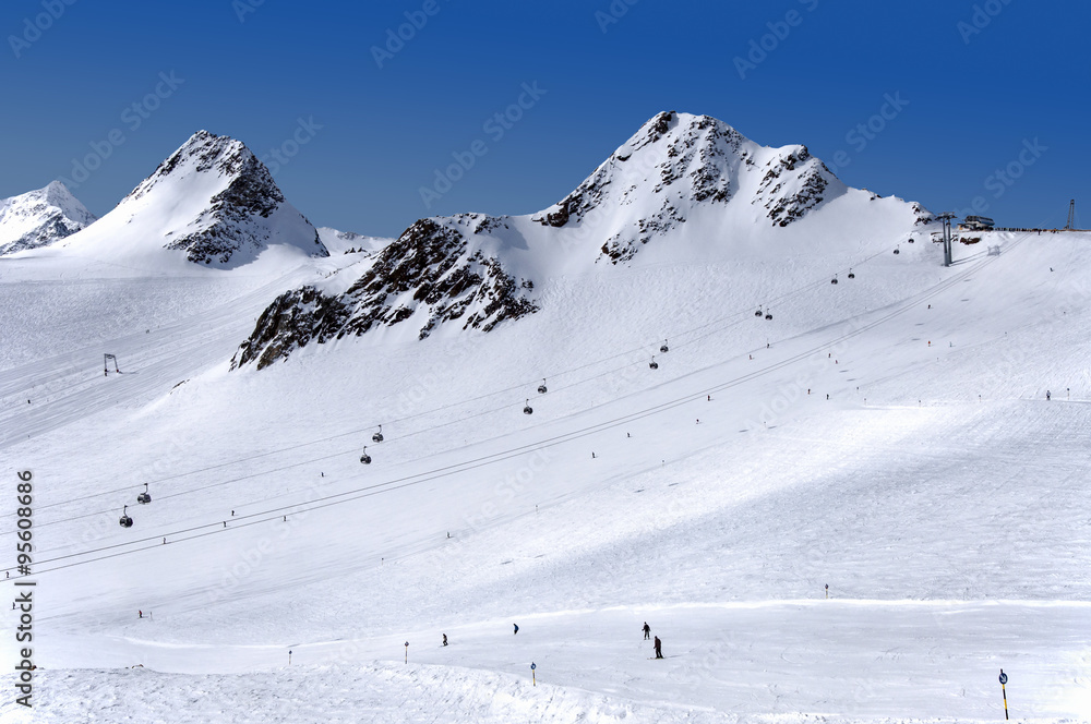 Gondola cable car, ski tow, ski slope and skiers on Tiefenbach glacier in Solden ski resort, Tirol, Austria