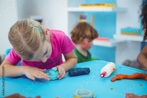 Obraz na plátne Smiling kids using modelling clay
